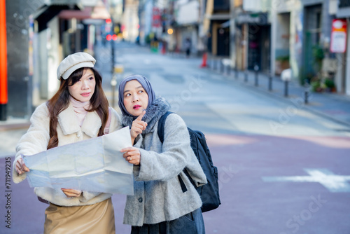 woman girl tourist Two Asian friends but different religions, one of whom is a Muslim girl. Looking at the tour map View information on traveling in Japan. with fun She is traveling in the city area. © maya1313