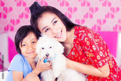 Fototapeta Naklejka Na Ścianę i Meble -  Cheerful young woman and her daughter holding a maltese dog