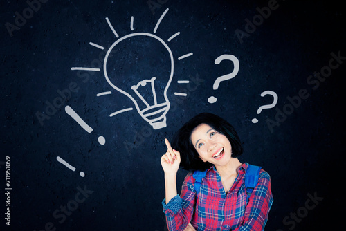 Asian woman having great idea against blackboard with lightbulb doodle