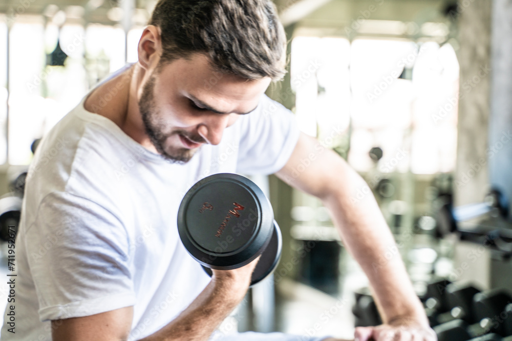Handsome Athletic Men Exercising With Dumnbell in Sport Fitness Gym Handsome Athletic Men Exercising With Dumnbell in Sport Fitness Gym