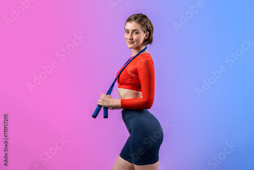 Full body length gaiety shot athletic and sporty young woman with fitness skipping rope in standing posture on isolated background. Healthy active and body care lifestyle. © Summit Art Creations
