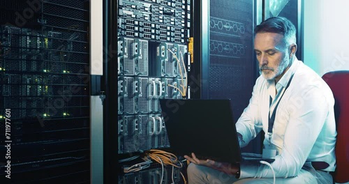 Mature man in data center with laptop, cable in network maintenance and engineer in digital storage for database update. Tech, system administration and technician online in server room with computer photo