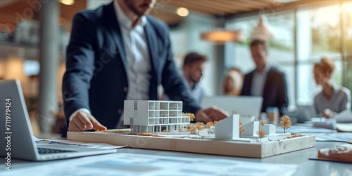 Business professionals with a model building and documents at a meeting. photo