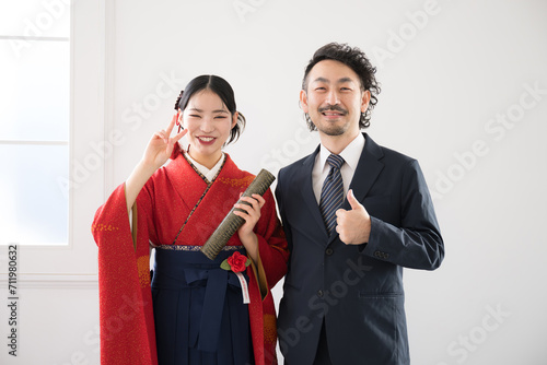 Parent and child (father and daughter) pose for a commemorative photo at a college graduation ceremony photo