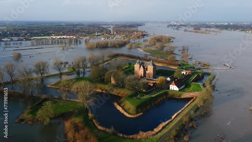 Low aerial orbiting view of the historic Slot Loevestein castle surrounded by flood waters as the Waal River overflows its banks after heavy rains pummel Northern Europe photo