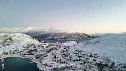 Aerial establishing shot of ersfjordvegen surrounded by snowy mountains photo