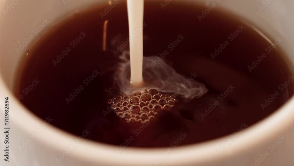 Macro shot captures milk pouring into a coffee cup, revealing intricate details. Simple yet visually appealing, portraying the everyday beauty of this routine. LuPa Creative.