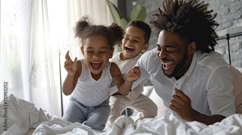 Happy family multiethnic mother, father and son laughing, playing, and jumping in bed in bedroom at home