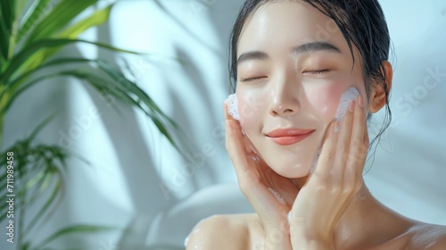 Portrait of Asian woman applying foam for washing on her face with attractive appearance. Skincare spa relax concept.
