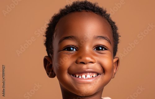 Portrait of a child black boy against a light brown background © Sattawat
