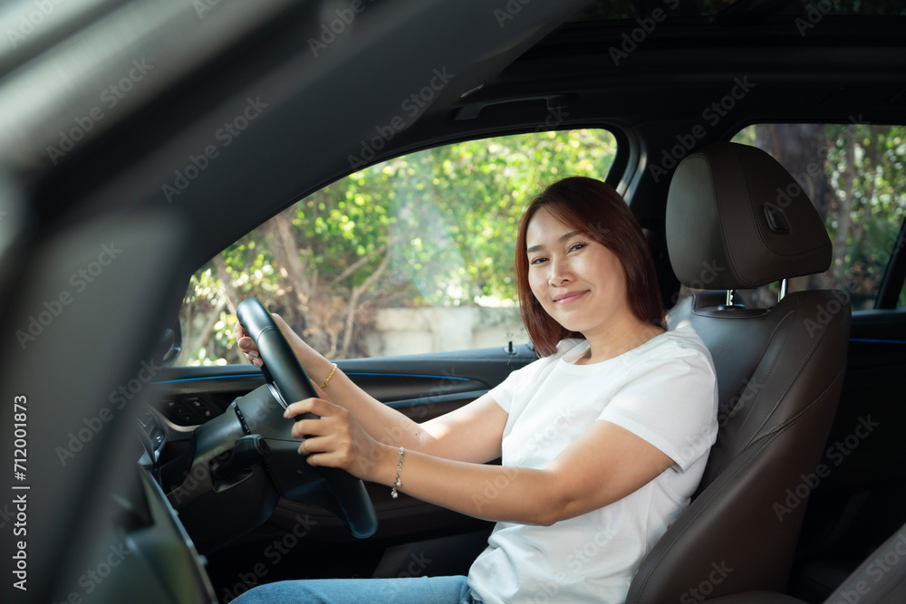 Asian women driving a car and smile happily Asian women driving a car and smile happily