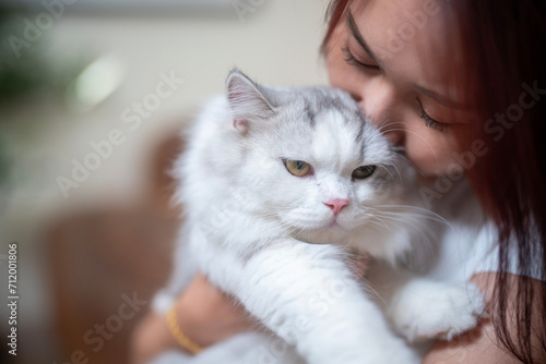 Portrait of a young woman hugging a cute cat
