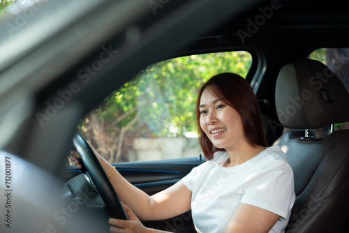 Asian women driving a car and smile happily