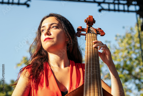 Woman musician playing cello outdoors photo