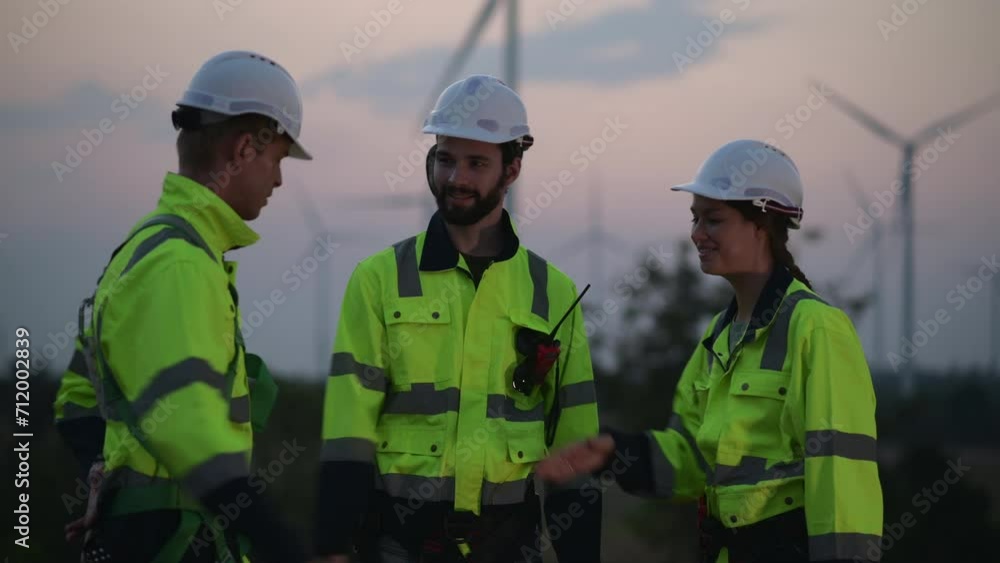 Team of engineers working on site in wind turbine farm, Wind turbines generate clean energy source, Eco technology for electric, industry environment Team of engineers working on site in wind turbine farm, Wind turbines generate clean energy source, Eco technology for electric, industry environment