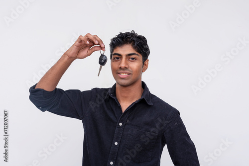 Photos Smiling young man holding car keys on white background