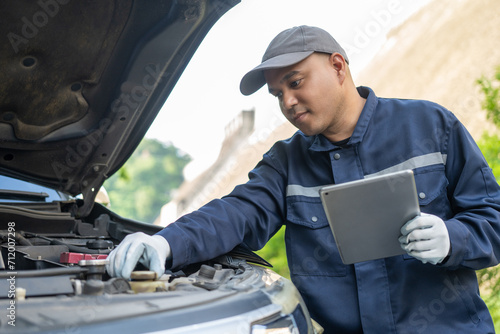 Professional car mechanic maintenance vehicle. The mechanic opens the front of the car. Checking the broken engine. Check the damage as listed. Repair car outside service.