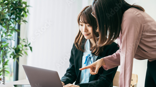 パソコンを使ってミーティングをする2人のビジネスウーマン photo