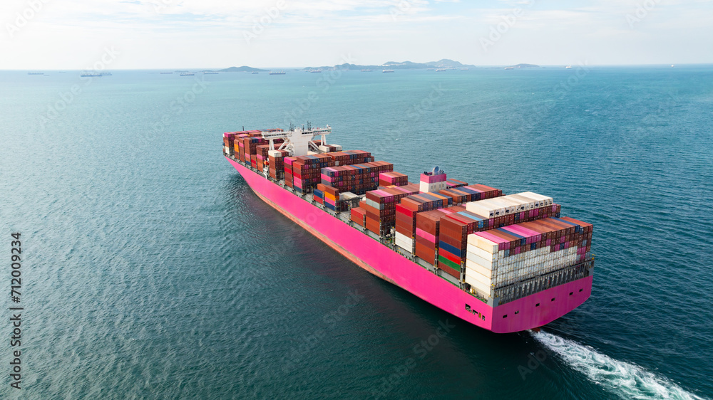 Fototapeta premium global business cargo logistic container ship sailing in sea import export goods and distributing products to dealer and consumers worldwide, back view from drone,