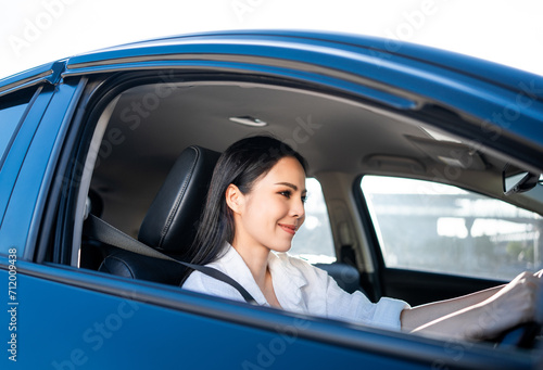 Young beautiful asian business women getting new car. She very happy and excited. Smiling female driving vehicle on the road on a bright day with sun light. Business woman buying driving new car © Chanakon