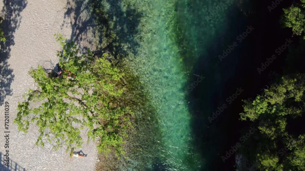 custom made wallpaper toronto digitalTop-down view of the famous Voidomatis River that flows through the Vikos National Park in Epirus, Greece. There is a woman lying on the pebbly riverbank and enjoying the sun