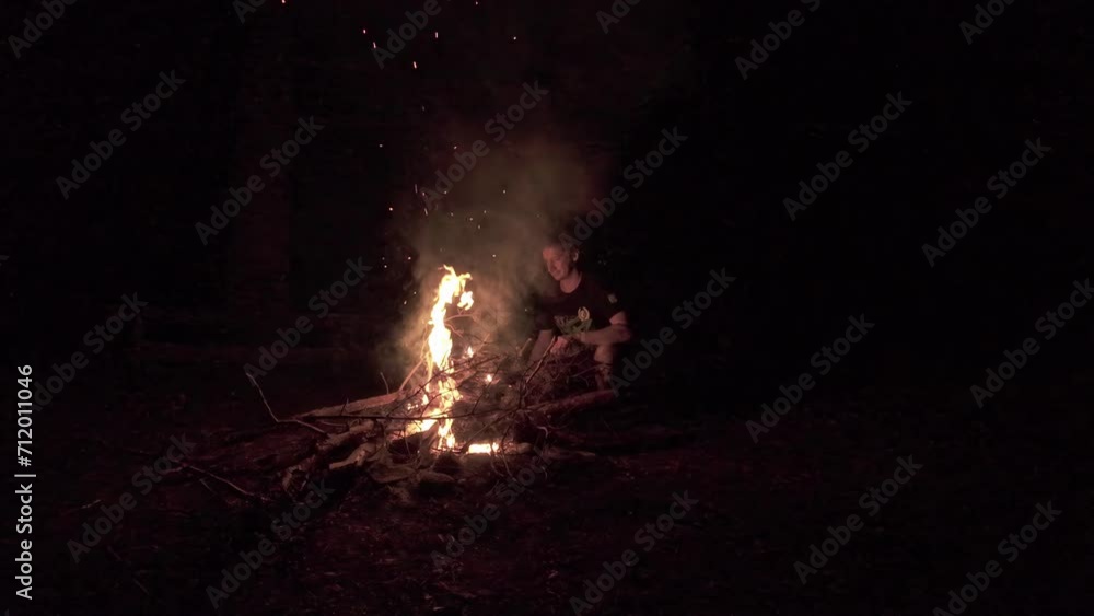Shot of a man standing and warming himself using fire outdoor during a winter night. Shot of a man standing and warming himself using fire outdoor during a winter night.