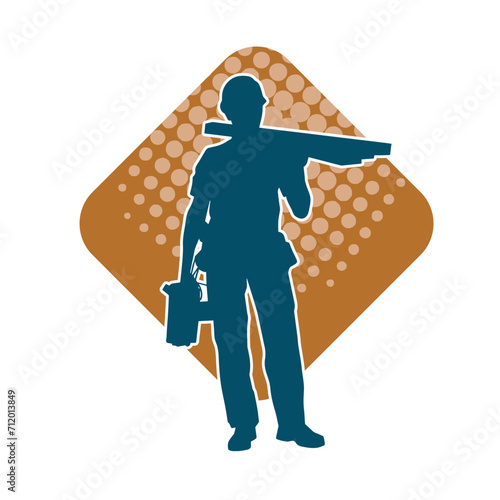 Silhouette of a construction worker carrying wood boards.