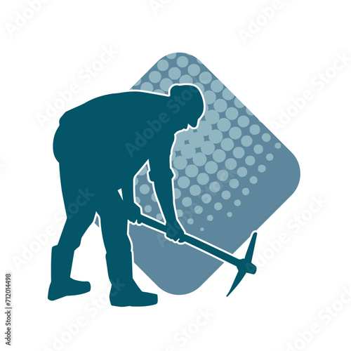 Silhouette of a man in worker costume carrying pick axe tool in action pose. Silhouette of a miner in action pose with pick axe tool.