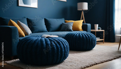 Two knitted poufs near dark blue corner sofa Scandinavian home interior design of modern living room style