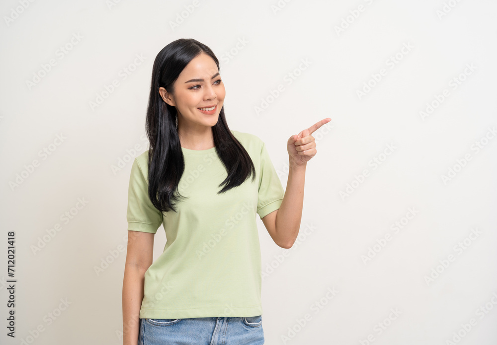 Beautiful smiling happy young asian woman in green shirt. Charming female lady pointing finger to copy space on isolated white background. Asian woman cute Pretty people looking blank space. Beautiful smiling happy young asian woman in green shirt. Charming female lady pointing finger to copy space on isolated white background. Asian woman cute Pretty people looking blank space.