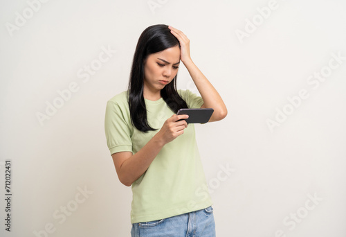 Stressed Boring Young pretty asian woman playing game. Latin female Gamer holding cell phone play video game online feeling sadness. Loss and Missed the chance to become a champion