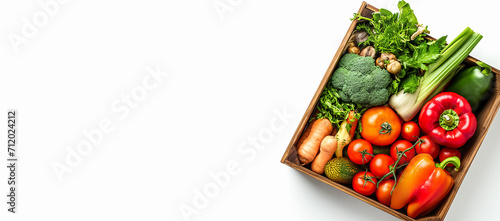 Fresh ripe vegetables in a wooden box on a white background with a blank area for the texting, copy space.