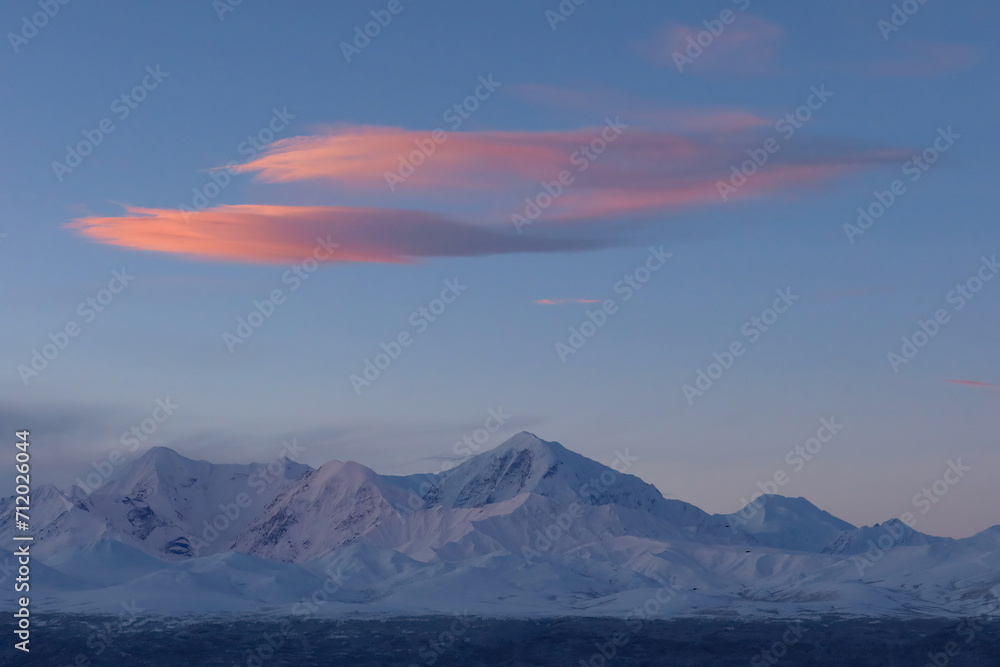 Pink morning clouds float over mountains of the Alaska Range.