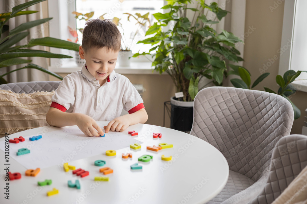 A Caucasian light-haired boy of five years old with blue eyes is putting together a puzzle A Caucasian light-haired boy of five years old with blue eyes is putting together a puzzle