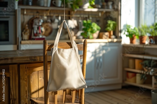White tote bag hanging on a chair in a sunny kitchen interior.