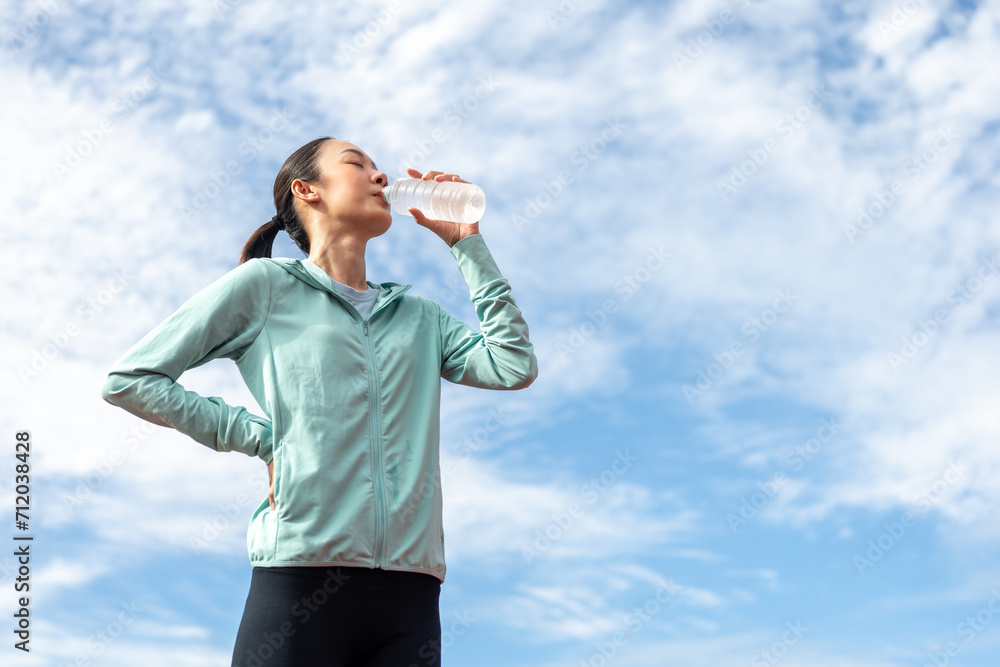 Happy slim asian woman drinking water after workout exercising on running track at sport stadium. Young beautiful asian drinking water after jogging running outdoor. Healthy and active lifestyle. Happy slim asian woman drinking water after workout exercising on running track at sport stadium. Young beautiful asian drinking water after jogging running outdoor. Healthy and active lifestyle.