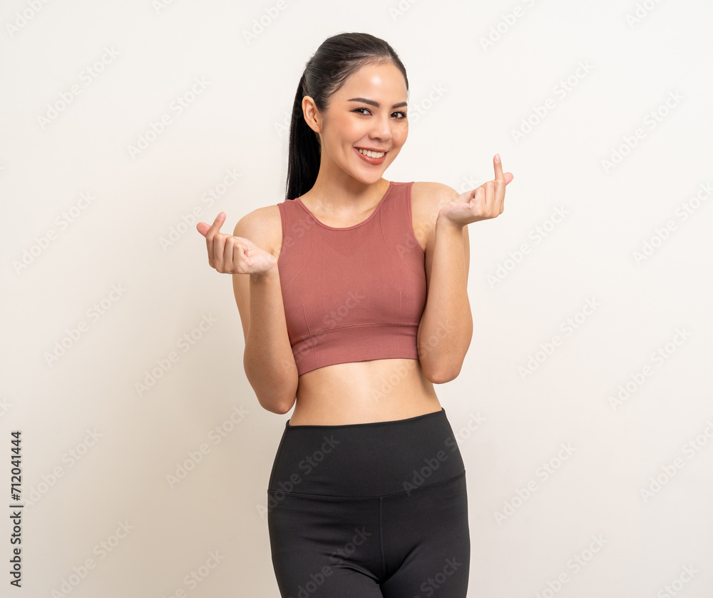 Young beautiful smiling asian woman with sportswear showing mini heart on isolated white background. Portrait happy healthy slim fit and firm latin attractive sporty woman heart sign pose Young beautiful smiling asian woman with sportswear showing mini heart on isolated white background. Portrait happy healthy slim fit and firm latin attractive sporty woman heart sign pose