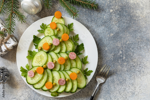 Christmas tree from a salad olivier on a gray stone background. Christmas appetizer. View from above. Copy space.