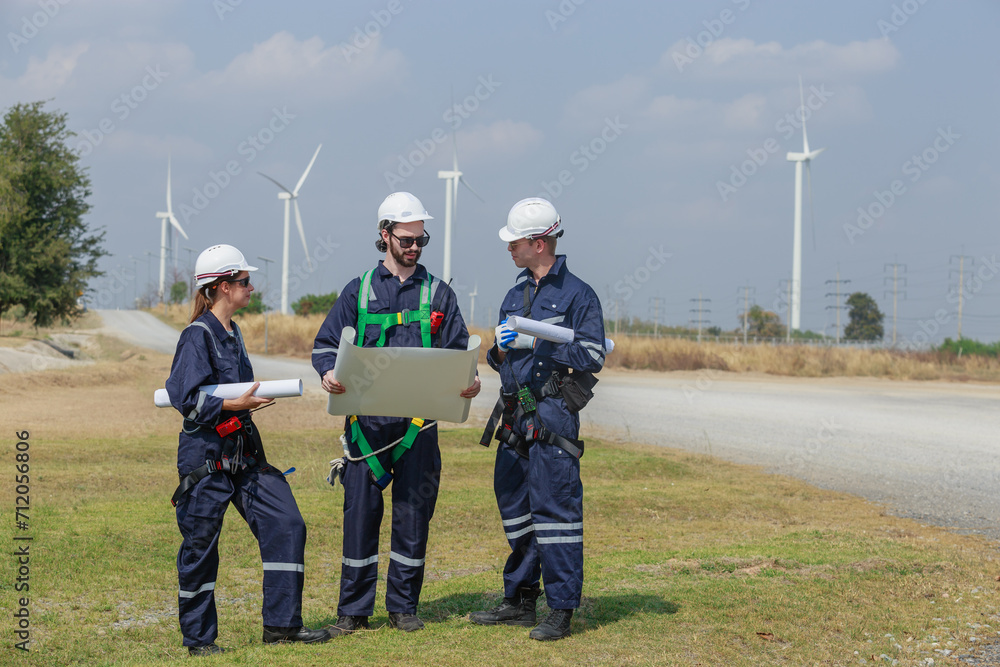 Team engineer wind turbine worker safety uniform holding blueprint survey discuss operational planning windmill field clean energy. Alternative technology protect environment. Team engineer wind turbine worker safety uniform holding blueprint survey discuss operational planning windmill field clean energy. Alternative technology protect environment.