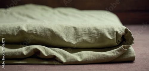  a close up of a bed with a green comforter and a pillow on top of a bed with a wooden headboard in the back of the headboard.