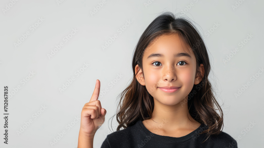 Beautiful Asian girl, pointing finger up at copy space isolated on background. Beautiful Asian girl, pointing finger up at copy space isolated on background.