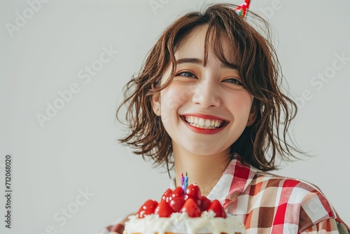 ケーキを手に笑顔で幸せそうな日本人女性（誕生日・お祝い・記念日）