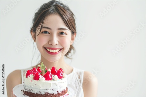 ケーキを手に笑顔で幸せそうな日本人女性（誕生日・お祝い・記念日）