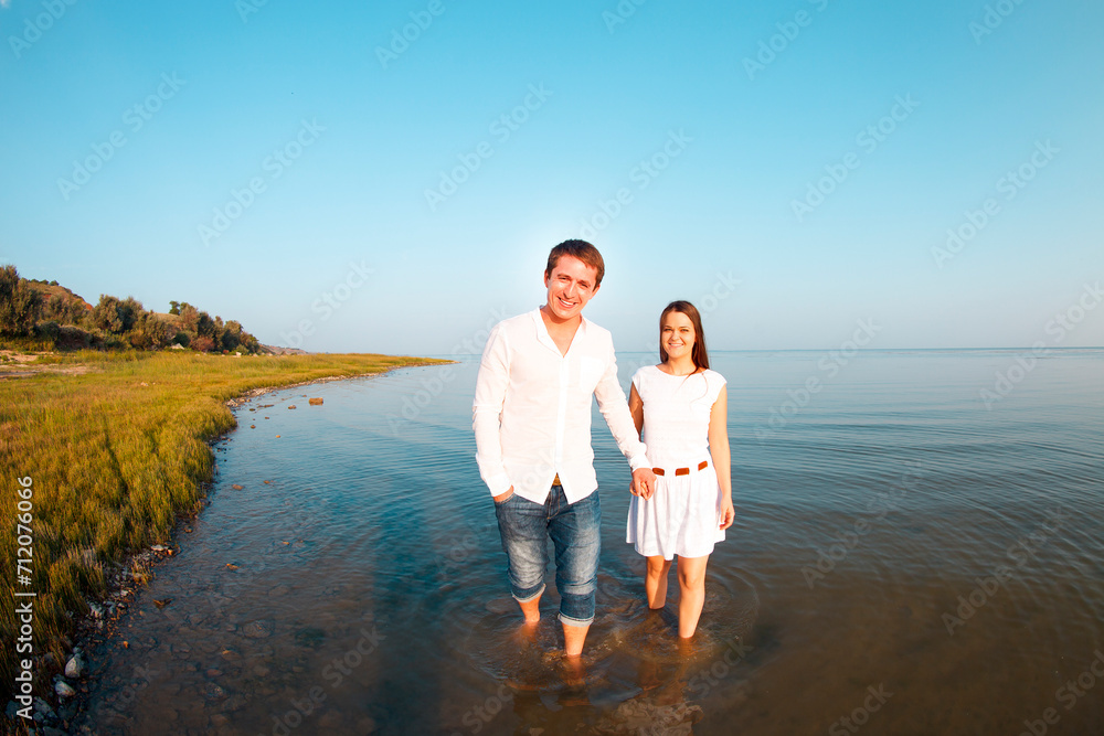 Young happy couple in love by the sea in summer day Young happy couple in love by the sea in summer day