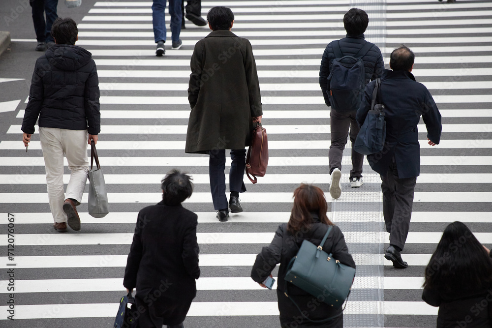 Obraz premium 冬の都市の交差点の横断歩道を渡る人々の姿