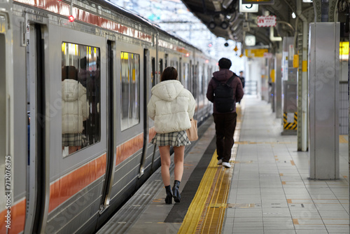 冬の名古屋駅のホームで歩く若い女性と男性の姿