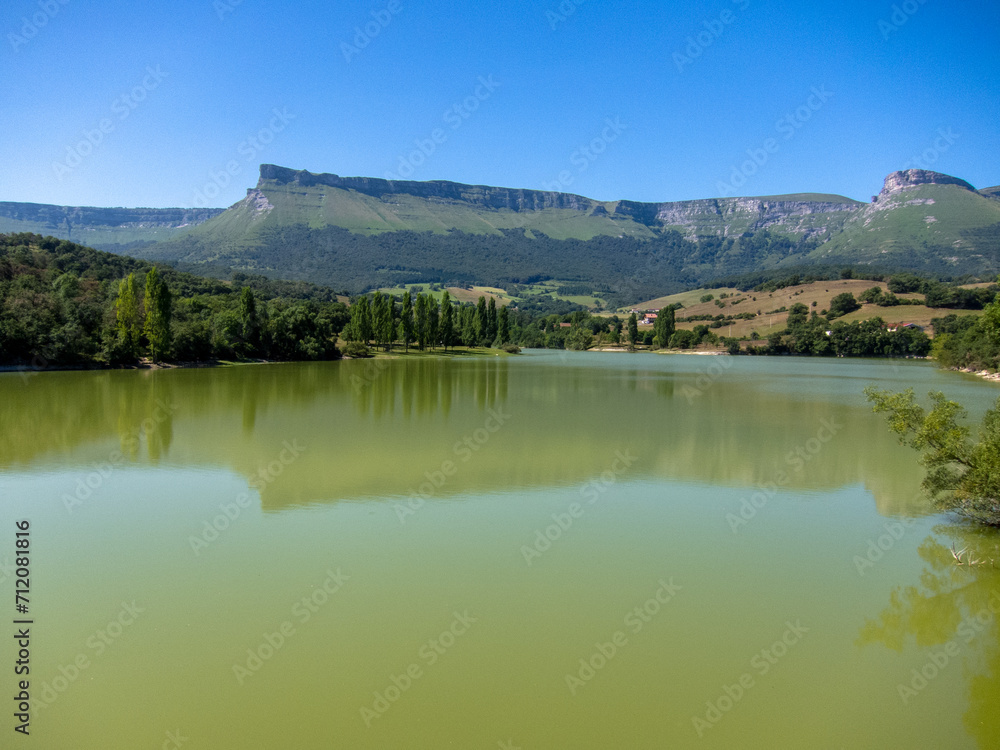 Panoramic view of the Maroño reservoir in Vitoria surrounded by mountains, trees and lots of vegetation on a sunny day in Alava.