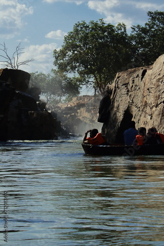 coracle boat riding on kaveri river canyon, front of hogenakkal waterfall in tamilnadu, south india photo