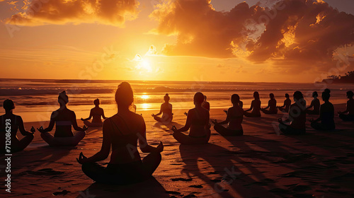 yoga retreat on the beach at sunset  silhouettes of group of people meditating