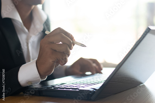 Businessmen or accountants work on computers and record business documents on their desks.